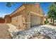 View of the home's desert landscaping, two-car garage and covered walkway, enhancing its curb appeal at 4037 Vulcan St, Las Vegas, NV 89122