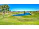 Scenic view of the lush green golf course with a tranquil pond and mountain backdrop at 4037 Vulcan St, Las Vegas, NV 89122