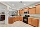 Well-lit kitchen with wood cabinets, granite countertops, and black gas range at 4037 Vulcan St, Las Vegas, NV 89122