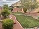 Landscaped backyard with a stone walkway, lush green lawn, and privacy fence at 4121 Erinbird Ave, North Las Vegas, NV 89084