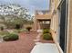 Backyard features a stone pathway, small trees, and a multi-level home at 4121 Erinbird Ave, North Las Vegas, NV 89084