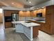Bright kitchen featuring wood cabinets, tile countertops, a center island with a sink, and modern appliances at 4121 Erinbird Ave, North Las Vegas, NV 89084