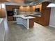 Spacious kitchen featuring wood cabinets, tile countertops, a center island with a sink, and modern appliances at 4121 Erinbird Ave, North Las Vegas, NV 89084