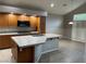 Well-lit kitchen featuring wood cabinets, a center island with a sink, and modern appliances at 4121 Erinbird Ave, North Las Vegas, NV 89084