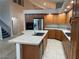 Open kitchen with wooden cabinets, granite counters, a large island with sink, and stainless steel appliances at 4121 Erinbird Ave, North Las Vegas, NV 89084