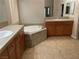 Bathroom featuring a large tub, double sinks, tile floor and wood cabinetry for ample storage at 4121 Erinbird Ave, North Las Vegas, NV 89084