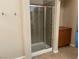 Elegant shower with glass doors, tile surround, and convenient storage at 4121 Erinbird Ave, North Las Vegas, NV 89084