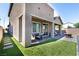 Inviting backyard with artificial grass, covered patio, and stone pavers perfect for outdoor entertaining at 4376 Latitude Valley Ct, North Las Vegas, NV 89084