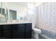 Bathroom with a shower, blue decor, a mirror and a single vanity with dark cabinets at 4376 Latitude Valley Ct, North Las Vegas, NV 89084