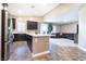 Modern kitchen with stainless steel appliances, dark cabinets, and an island flowing into the living room at 4376 Latitude Valley Ct, North Las Vegas, NV 89084