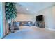 Bright living room with a large sectional sofa, entertainment center, and a view of the sliding glass door at 4376 Latitude Valley Ct, North Las Vegas, NV 89084