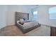 Elegant main bedroom featuring a tufted headboard bed, two windows, and neutral carpeting at 4376 Latitude Valley Ct, North Las Vegas, NV 89084