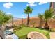 Beautiful backyard with a putting green, fire pit, palm trees, desert landscaping, and mountain views at 44 Moon Hill Dr, Henderson, NV 89011