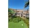 Green backyard with putting green, flowers, and views of the neighborhood beyond the metal fence at 44 Moon Hill Dr, Henderson, NV 89011
