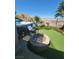 A backyard featuring a jacuzzi, fire pit, putting green, landscaping, and neighborhood views at 44 Moon Hill Dr, Henderson, NV 89011