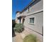 Side exterior view of a two-story home featuring neutral stucco, brick walkway and manicured landscaping at 44 Moon Hill Dr, Henderson, NV 89011