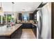 Beautiful kitchen featuring stainless steel appliances, dark cabinets, granite counters and a large island with pendant lights at 44 Moon Hill Dr, Henderson, NV 89011