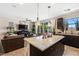 Open kitchen features large island, stainless steel appliances, dark cabinets and views to the living room and backyard at 44 Moon Hill Dr, Henderson, NV 89011
