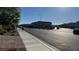 A wide street featuring single-Gathering homes and well-maintained sidewalks on a sunny day at 4752 Cactus Sun Ln, North Las Vegas, NV 89031