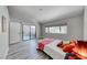 Spacious bedroom featuring wood-look floors, large windows, and sliding doors to a private balcony at 5018 S Rainbow Blvd # 202, Las Vegas, NV 89118