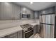 Well-lit kitchen with stainless steel appliances, quartz countertops, and modern gray cabinetry at 5018 S Rainbow Blvd # 202, Las Vegas, NV 89118