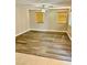 A spacious room featuring wood-look floors, a ceiling fan, and windows covered with wood-toned blinds at 5055 Lime Kiln Ave, Las Vegas, NV 89139
