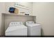 Convenient laundry room with a washer, dryer, shelving, and storage space for laundry essentials at 516 Hamilton Dr # Lot 25, Mesquite, NV 89027