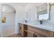 Modern bathroom with double sinks, lighted mirrors, and wood cabinets at 529 Fork Mesa Ct, Henderson, NV 89015