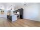 Open concept kitchen features dark cabinets, stainless steel appliances, a center island, and light flooring at 529 Fork Mesa Ct, Henderson, NV 89015