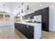 Open-concept kitchen featuring a large island, stainless steel appliances, dark cabinetry and modern lighting at 529 Fork Mesa Ct, Henderson, NV 89015