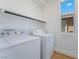 Clean laundry room with a stacked washer and dryer and bright window at 529 Fork Mesa Ct, Henderson, NV 89015
