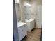 Bathroom featuring dual sink vanities, modern fixtures, and sleek floors at 5512 Del Lago Dr, Las Vegas, NV 89130