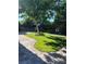 Well-kept backyard featuring a stone fire pit, green grass, and mature trees at 5516 Coyote Falls Ct, Las Vegas, NV 89131