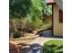Landscaped backyard featuring brick pathway, mature trees, and well-maintained plants at 5516 Coyote Falls Ct, Las Vegas, NV 89131