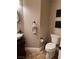 Powder room features a unique vanity, granite countertop, dark fixtures, and tiled floors adding a touch of elegance at 5516 Coyote Falls Ct, Las Vegas, NV 89131