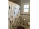 Bathroom featuring tile flooring, a patterned shower curtain, and gray tiled walls with natural light at 5516 Coyote Falls Ct, Las Vegas, NV 89131