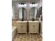 Bathroom featuring dual sinks, neutral stone counters, and decorative mirrors at 5516 Coyote Falls Ct, Las Vegas, NV 89131