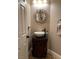 The powder room features a vessel sink, elegant mirror and dark faucet complementing its unique design and aesthetic at 5516 Coyote Falls Ct, Las Vegas, NV 89131