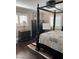 Bedroom with hardwood floors, plantation shutters, and a four-poster bed at 5516 Coyote Falls Ct, Las Vegas, NV 89131