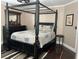 Bedroom with four poster bed, dark wood floors, and matching dresser with mirror at 5516 Coyote Falls Ct, Las Vegas, NV 89131