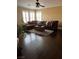 Living room with a large sectional sofa, and gleaming hardwood floors is complemented by natural light at 5516 Coyote Falls Ct, Las Vegas, NV 89131