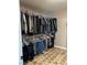 Spacious walk-in closet with dual hanging racks and tiled floors for storage and organization at 5516 Coyote Falls Ct, Las Vegas, NV 89131