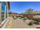 Backyard landscaped with gravel, bushes, and flowering plants, with a view of neighboring houses at 5650 Pleasant Palms St, North Las Vegas, NV 89081