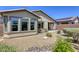 This backyard features low-maintenance desert landscaping, mature bushes, and a covered patio at 5650 Pleasant Palms St, North Las Vegas, NV 89081