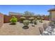 Low-maintenance backyard with gravel landscaping, bushes, and outdoor seating at 5650 Pleasant Palms St, North Las Vegas, NV 89081