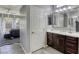 Bright bathroom features a double sink vanity with dark cabinets and a glimpse into an adjacent bedroom at 5650 Pleasant Palms St, North Las Vegas, NV 89081