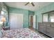Comfortable bedroom features a floral quilt, fresh paint and stylish dresser at 5650 Pleasant Palms St, North Las Vegas, NV 89081
