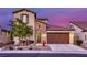 Charming two-story home with a brick-accented entrance and landscaped front yard at twilight at 5650 Pleasant Palms St, North Las Vegas, NV 89081