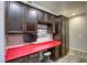 Home office featuring dark wood cabinets, red countertop, computer, and storage space at 5650 Pleasant Palms St, North Las Vegas, NV 89081