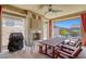 Cozy outdoor patio with a fireplace, ceiling fan, and a dining table for entertaining at 5650 Pleasant Palms St, North Las Vegas, NV 89081